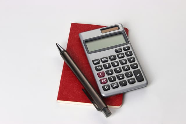 Calculator, notebook and pen used for property finance planning